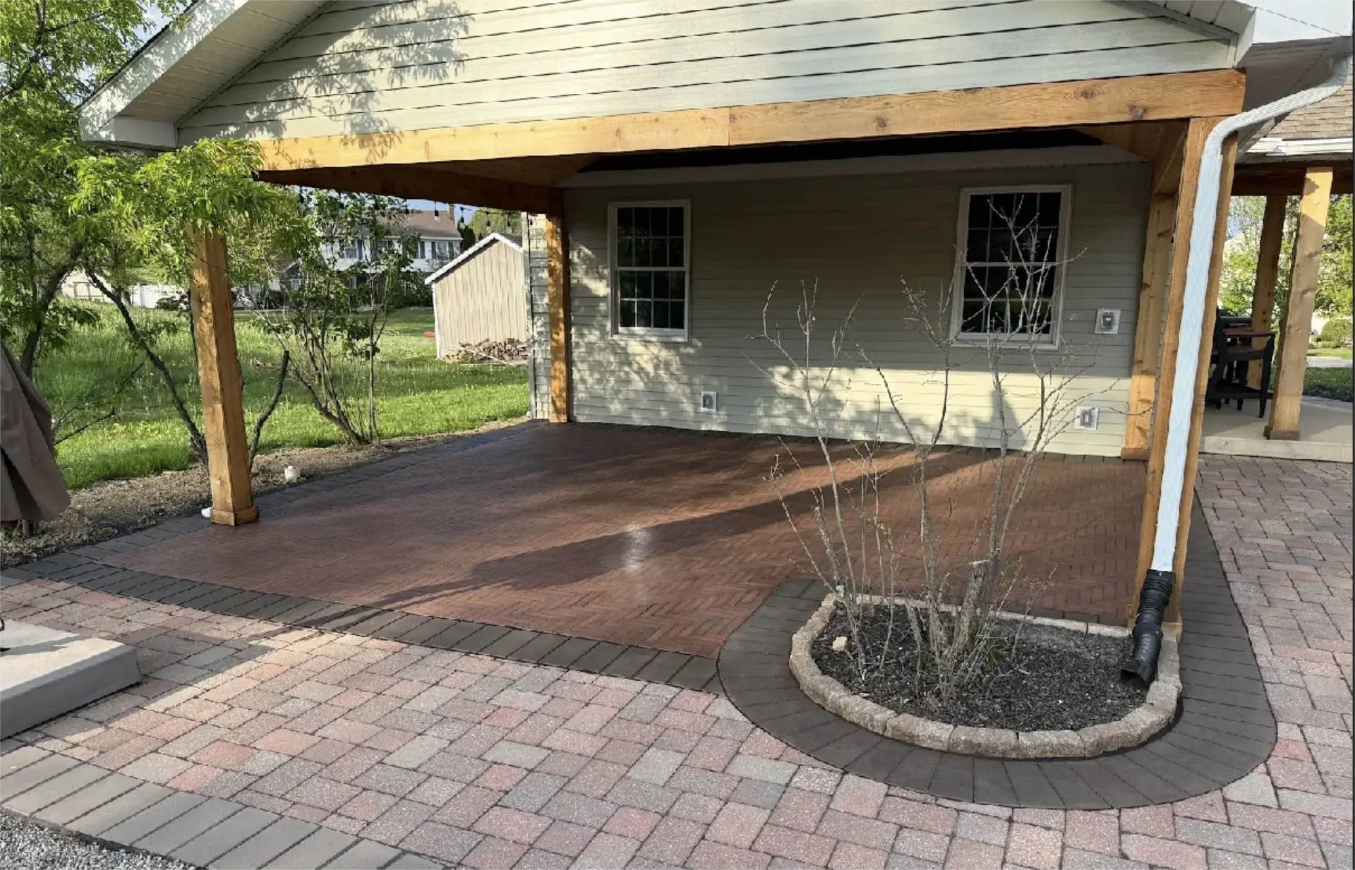 Backyard covered patio with herringbone brick floor.