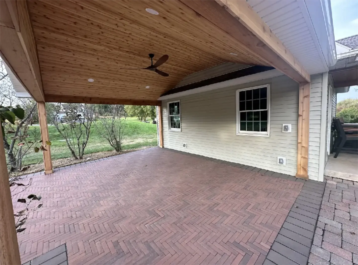 Brick pavers and covered patio with cedar ceiling.