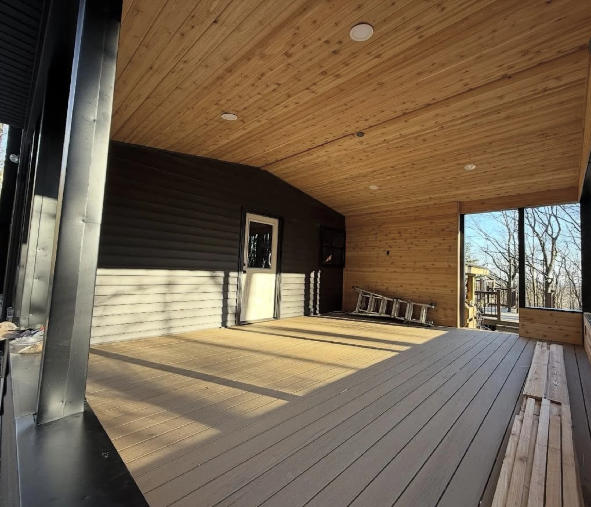 Covered deck with wood ceiling and composite flooring.