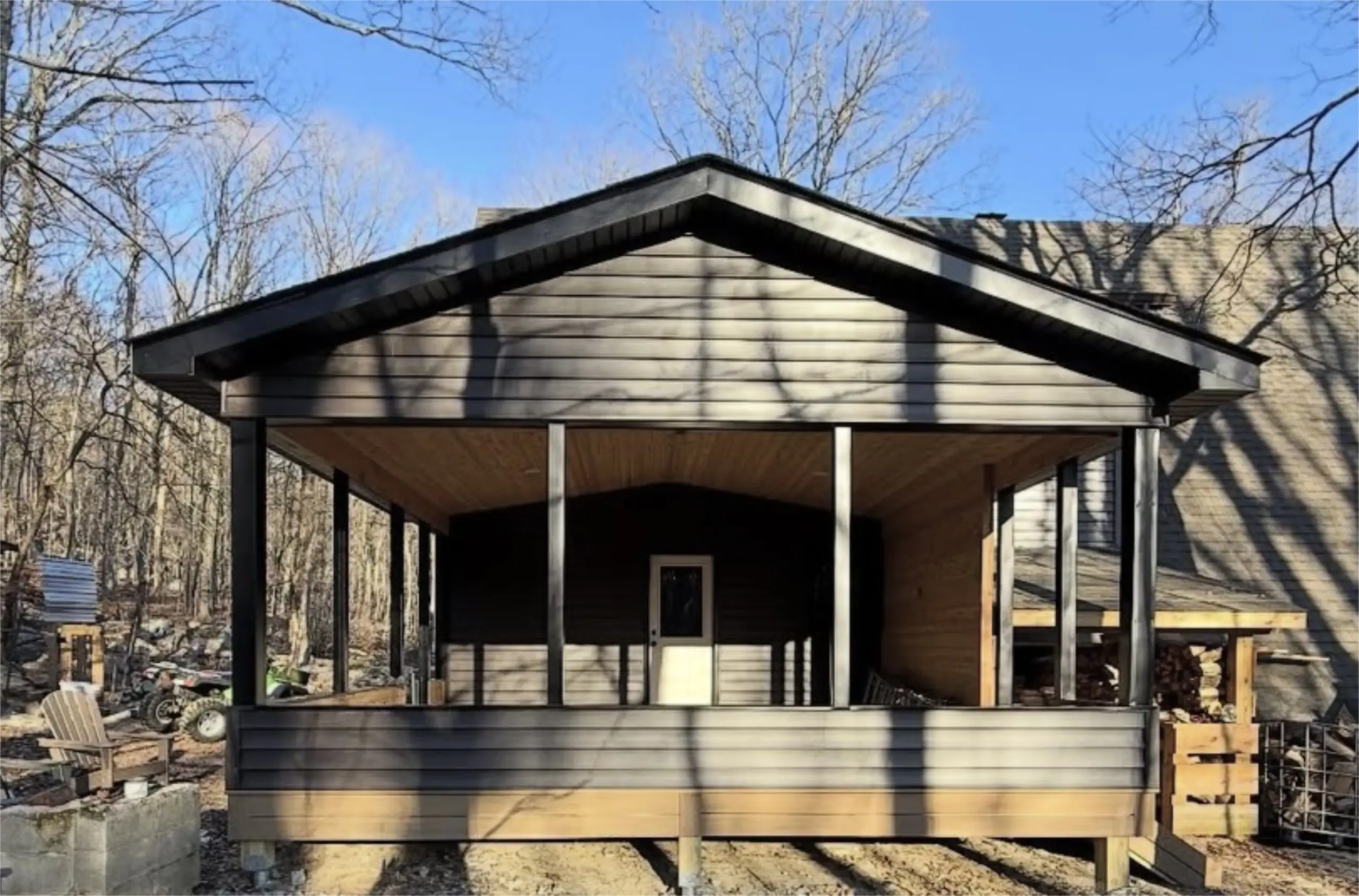Covered outdoor pavilion with black siding and wood interior.