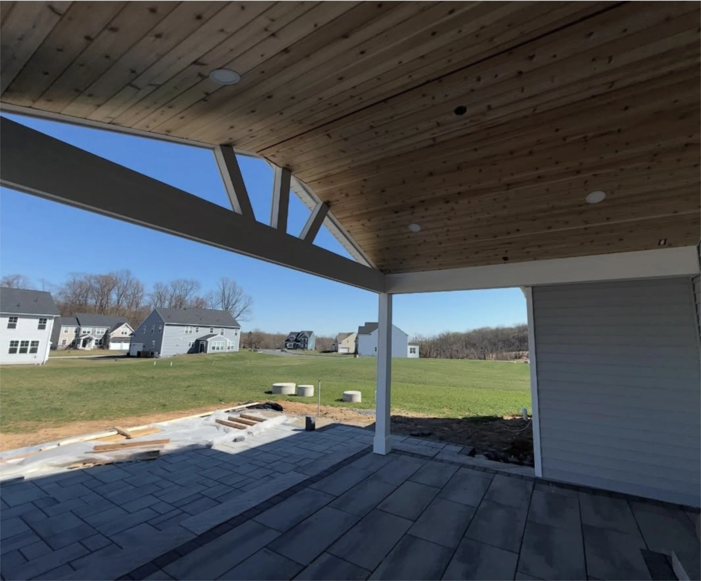 Covered patio with vaulted wood ceiling and open backyard view.