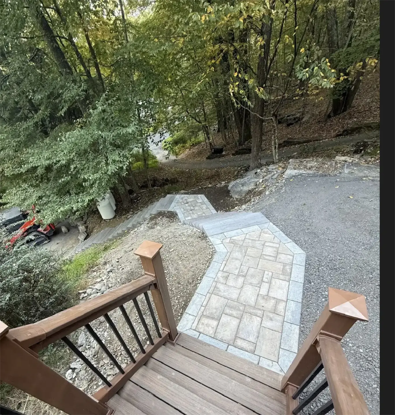Curved stone walkway and stairs leading into wooded yard.