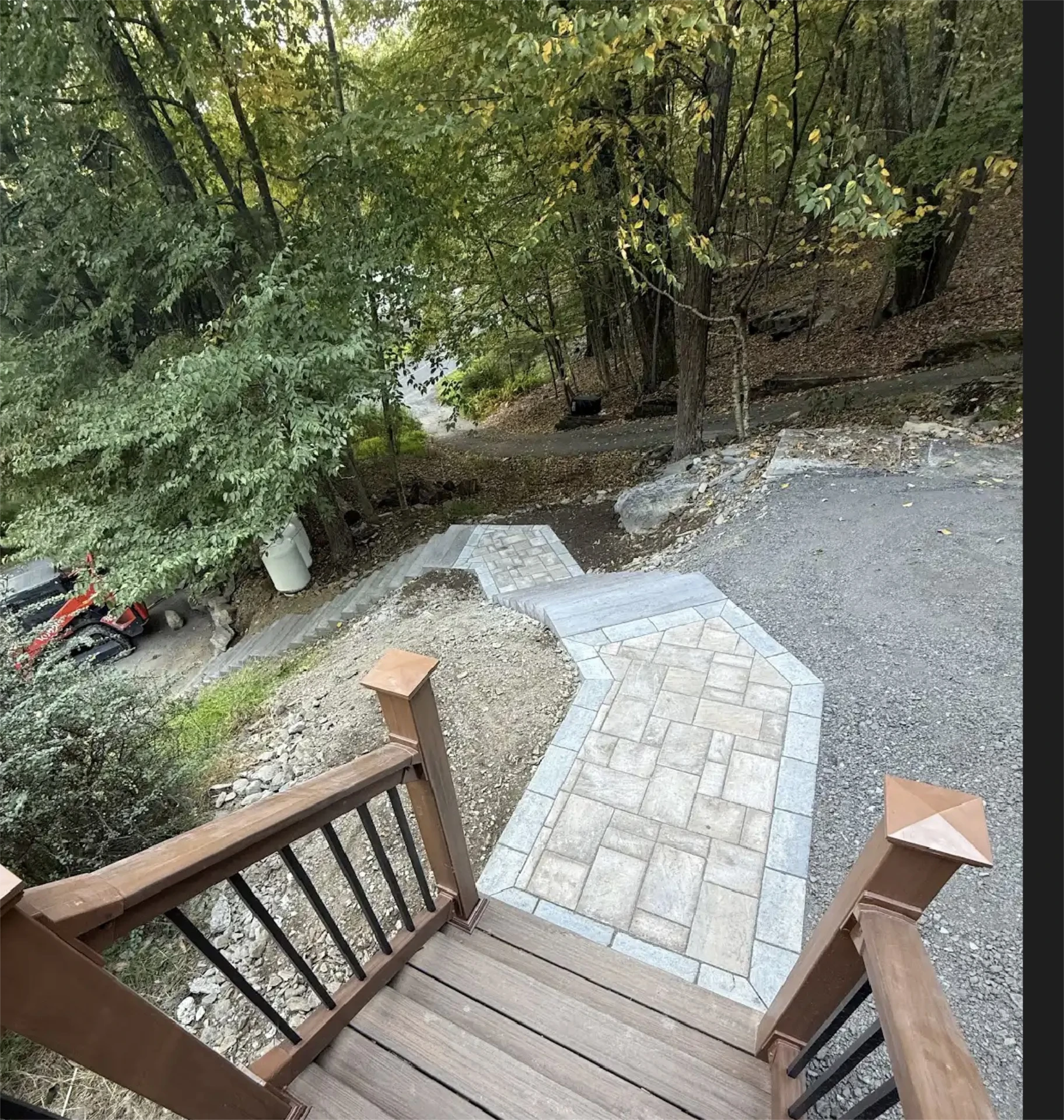 Curved stone walkway and stairs leading into wooded yard.