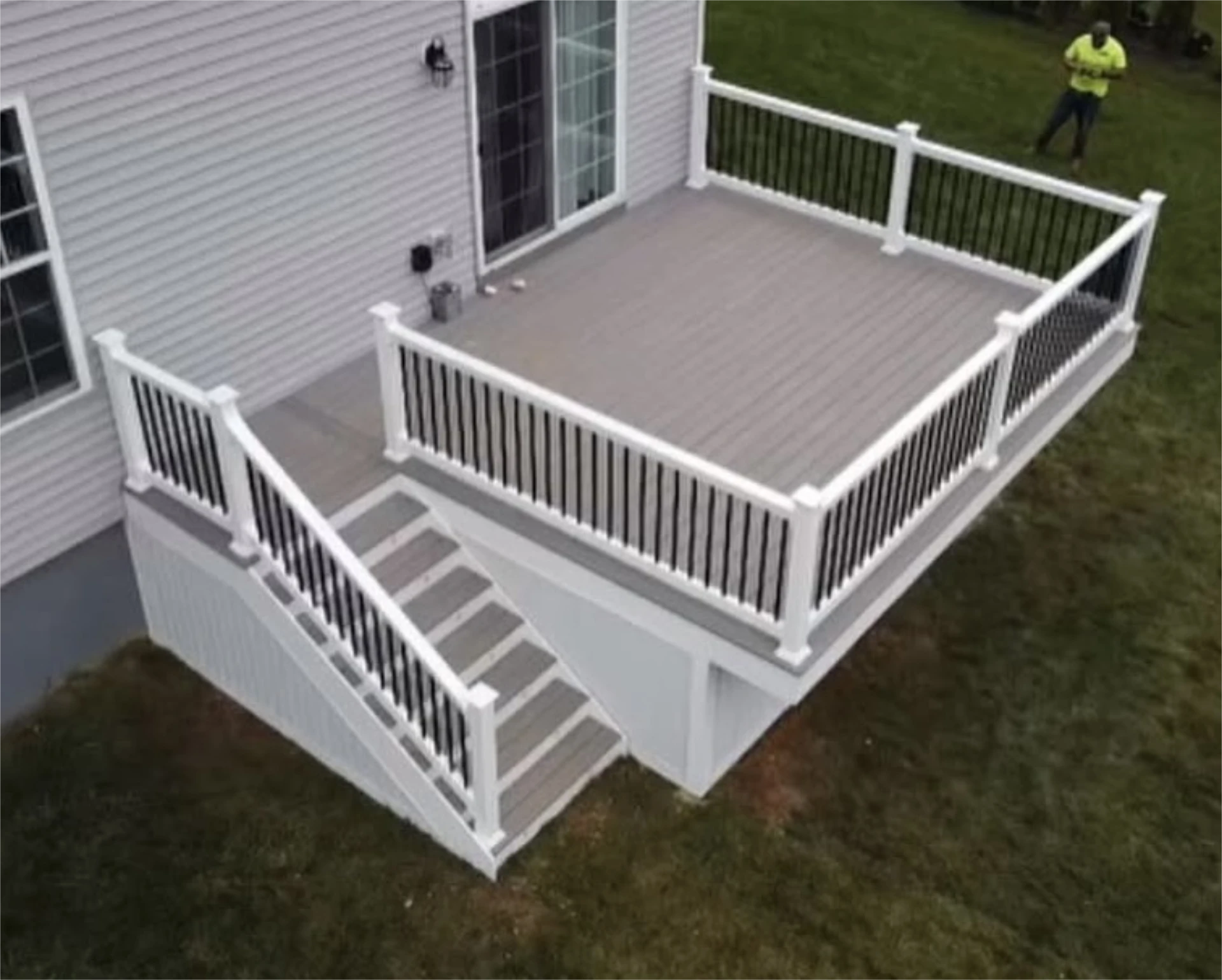 Elevated gray composite deck with white railing and stairs.