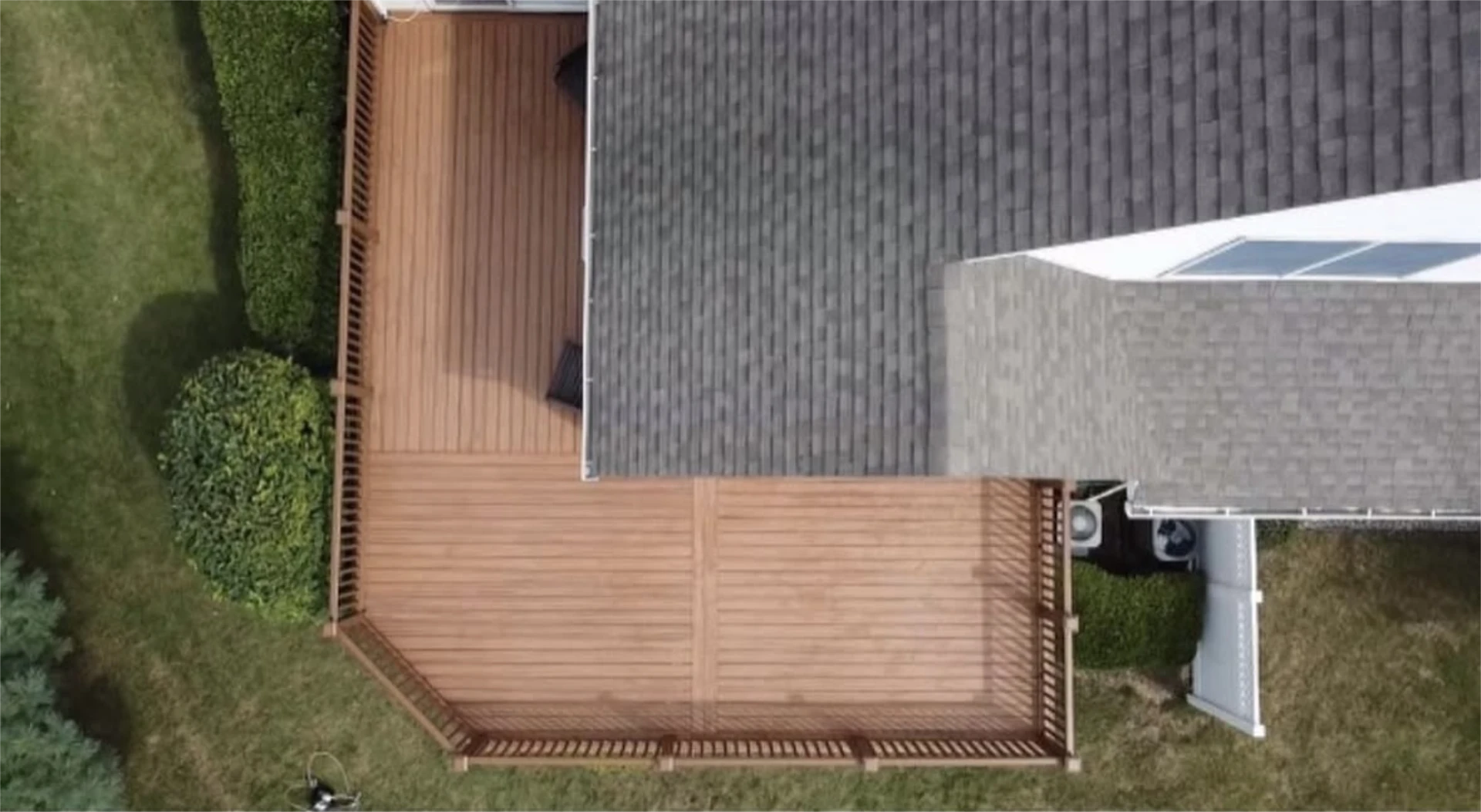 Large wooden backyard deck viewed from above.