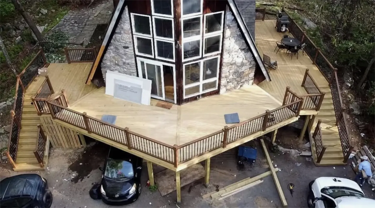 Large wooden deck with stairs around cabin.