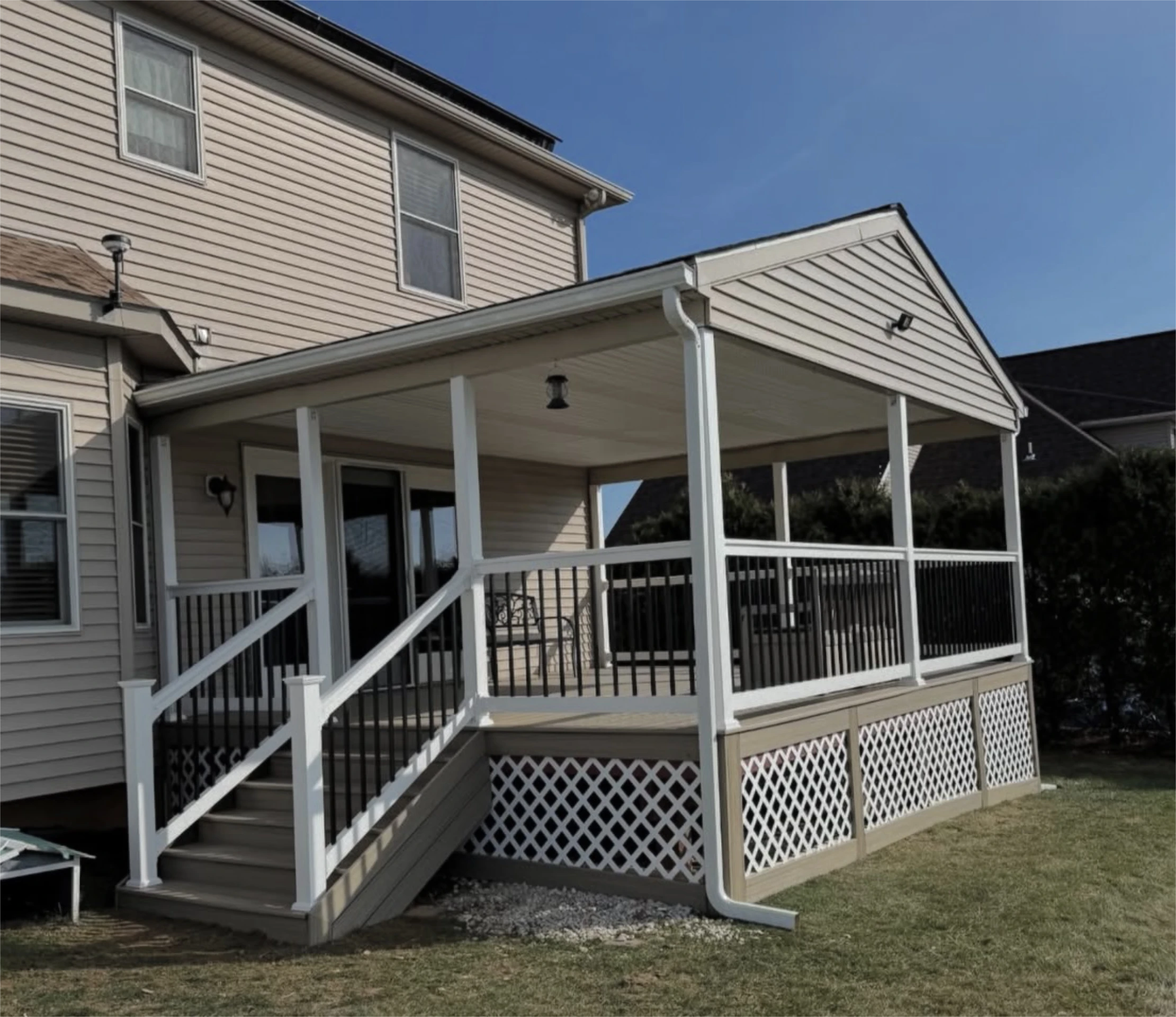 Raised covered deck with stairs and black railing accents.