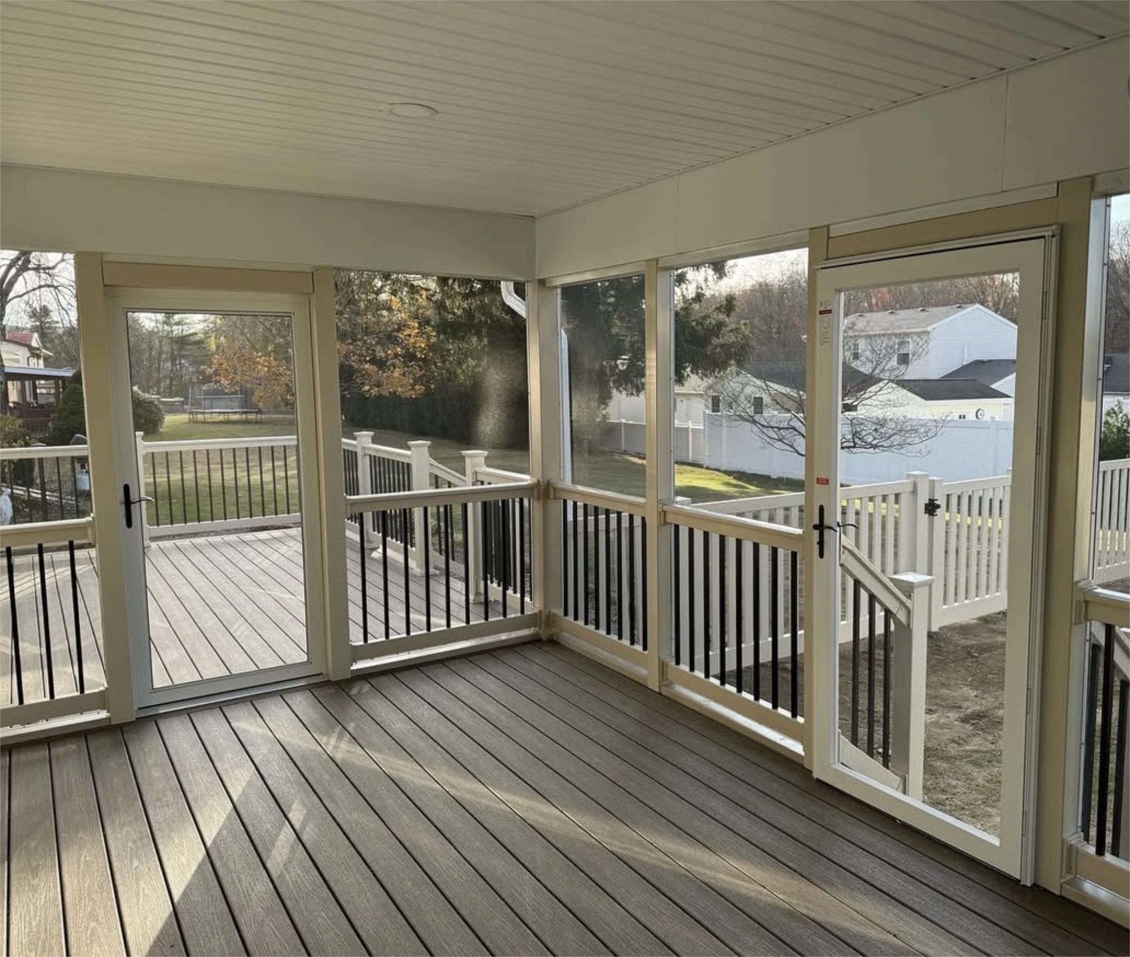 Screened in porch with composite flooring and dual doors.